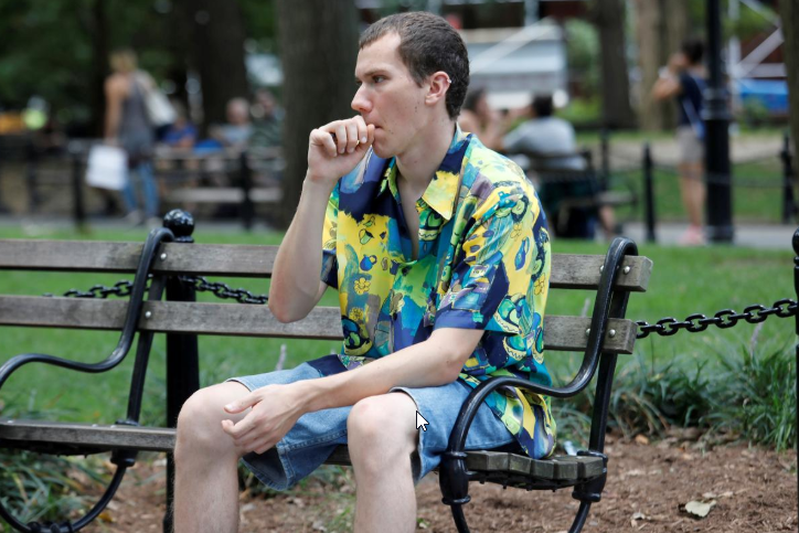 FILE PHOTO: Adam Trubitt, 21, vapes a Juul e-cigarette in Washington Square Park, Manhattan, New York, U.S., August 30, 2018. Picture taken August 30, 2018. To match Special Report VAPING-REGULATION/JUUL REUTERS/Shannon Stapleton - RC1693D4A300/File Photo